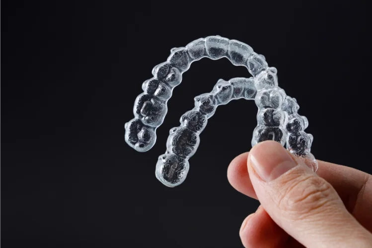A man holding a set of clear aligners